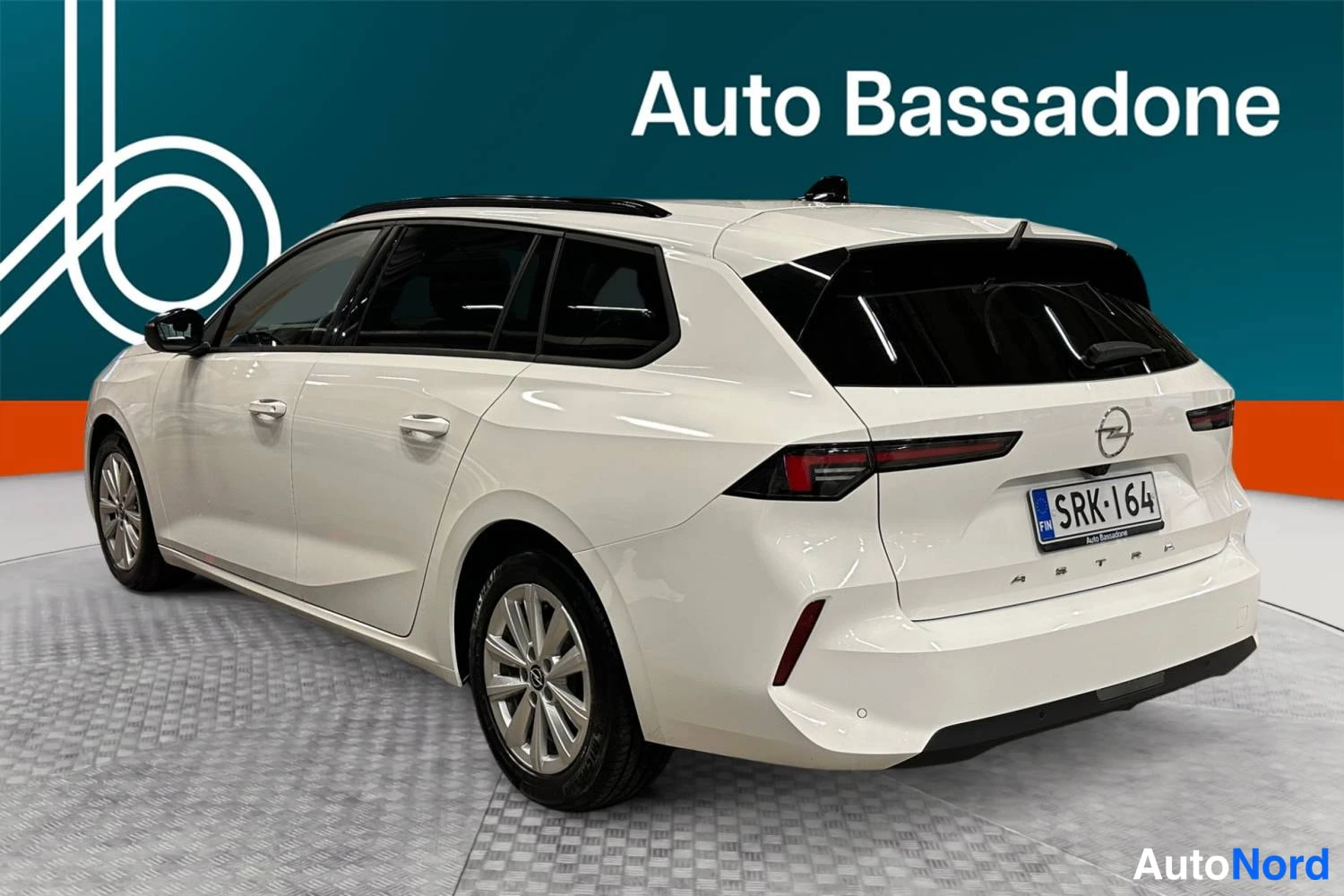 Vit Opel Astra Sports Tourer 2024, snett bakifrån, bild 6