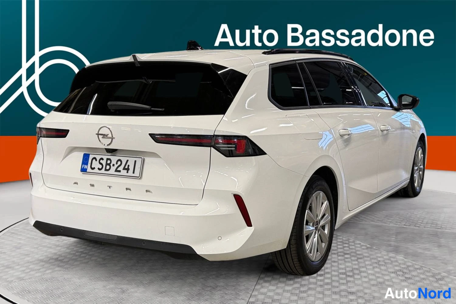 Vit Opel Astra Sports Tourer 2024, snett bakifrån, bild 6